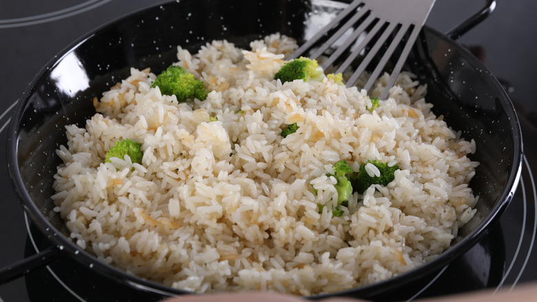 Rice and broccoli frying in a pan