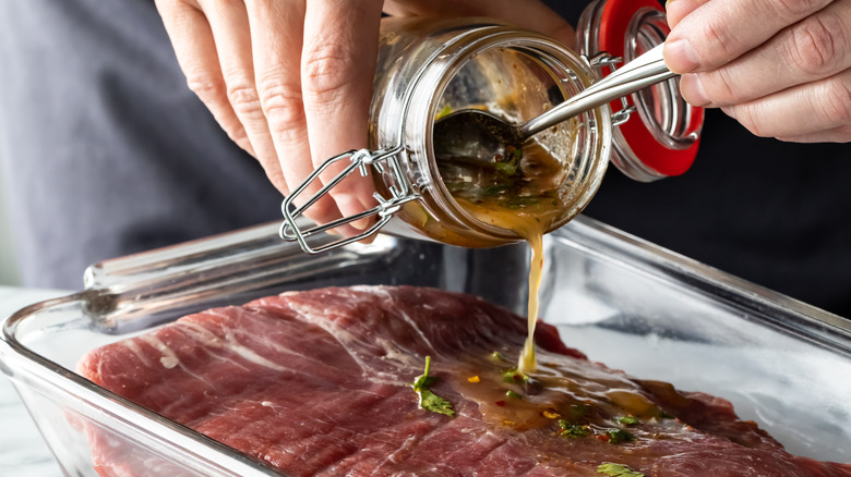 Marinade being poured on raw beef