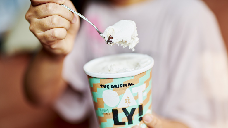 Hand holding spoonful of Oatly ice cream