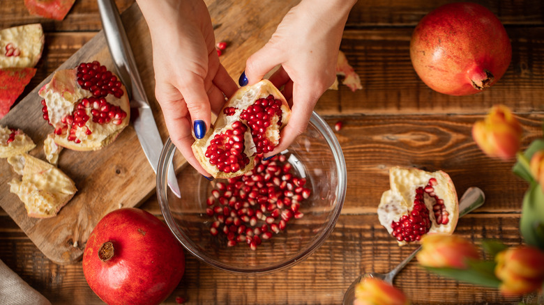 Woman removing pomegranate seeds 