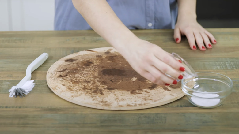 Cleaning pizza stone with baking soda and brush