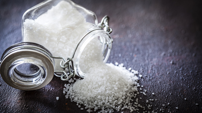 table salt spilled on black counter