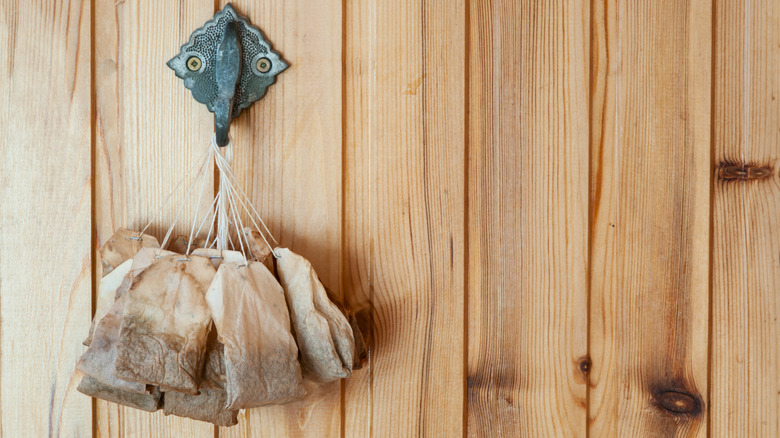 Used tea bags drying on a hook