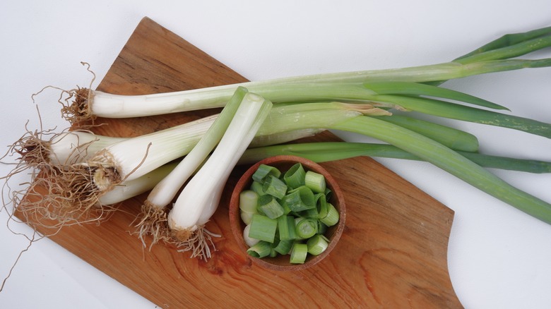 whole leeks and diced parts on cutting board