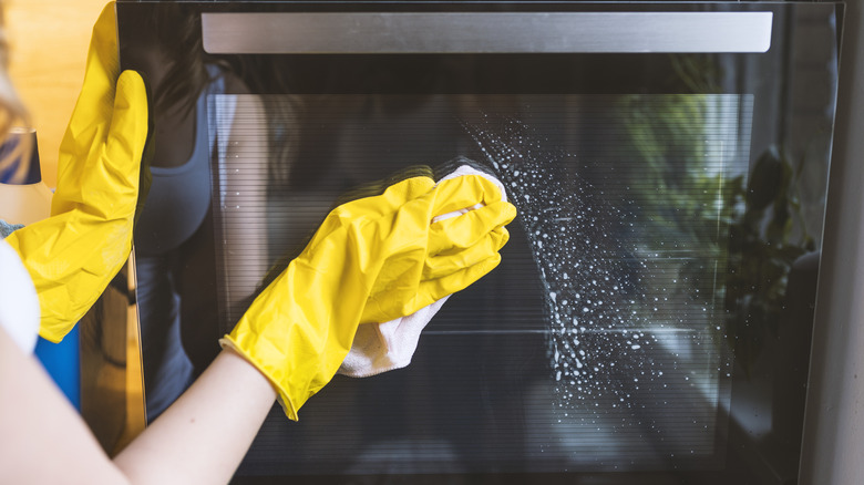 Person cleaning the outside of an oven