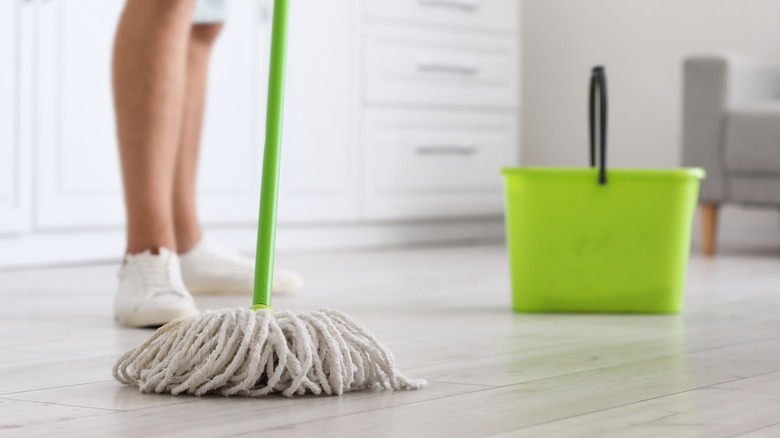Green mop and bucket shown on floor