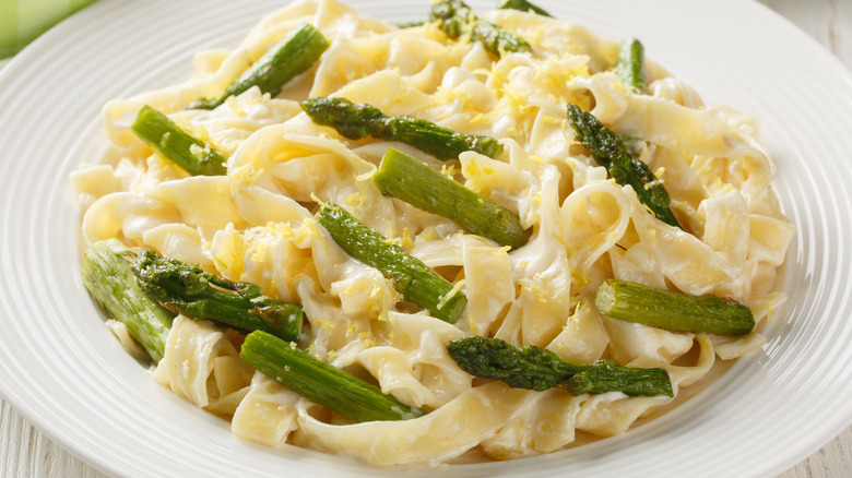 Fettuccine pasta dish topped with crispy asparagus