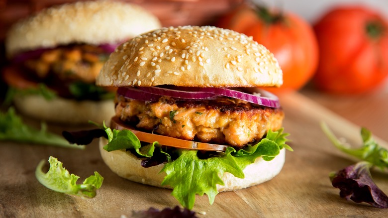 Classic salmon burger on wooden surface