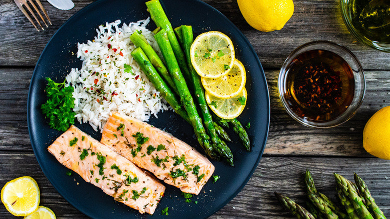 Steamed salmon with rice, lemons, and asparagus