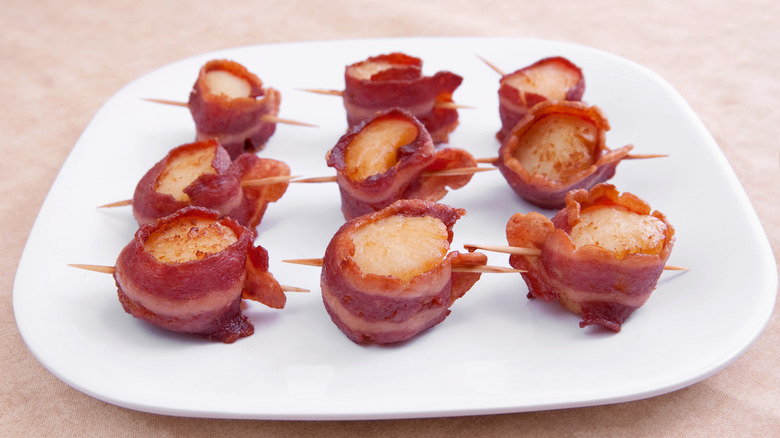Cooked scallops wrapped in bacon held together by toothpicks