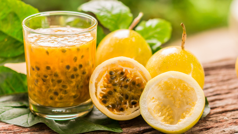 Passion fruit cut open with glass of juice