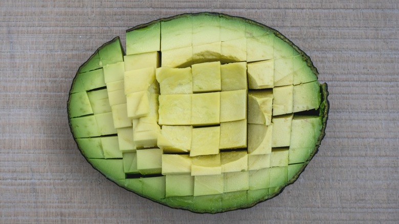 Diced avocado half in peel with crisscross sliced cubes