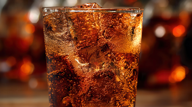 Closeup of a glass of dark-colored fizzy soda with ice