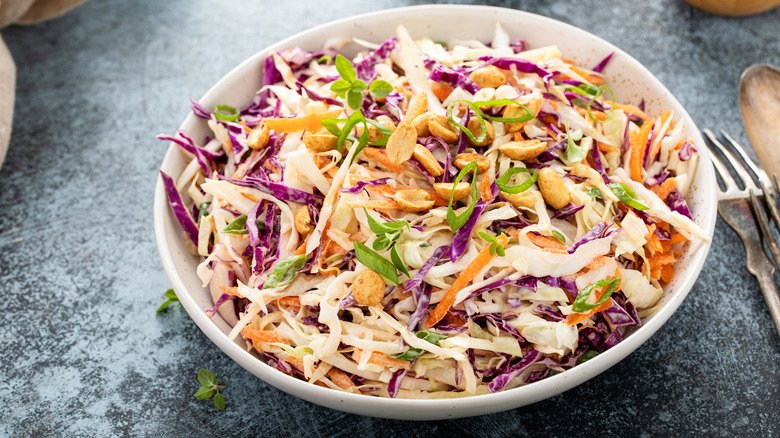 Asian cabbage coleslaw with peanut sauce, roasted peanuts, and green onions