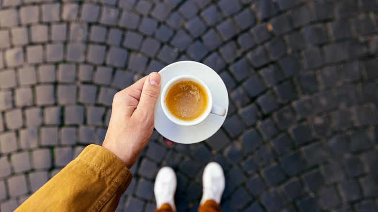 Person holding a cup of espresso