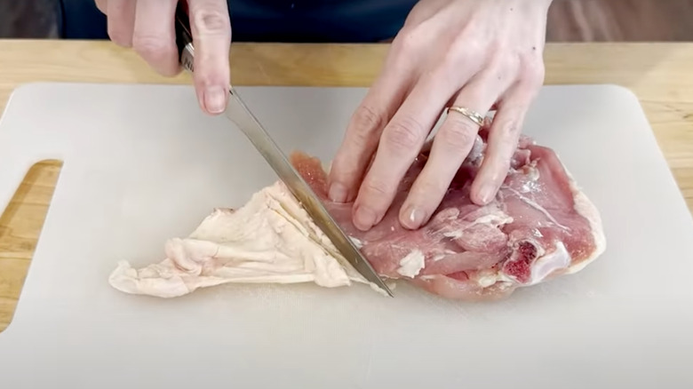 Trimming excess skin from chicken thighs