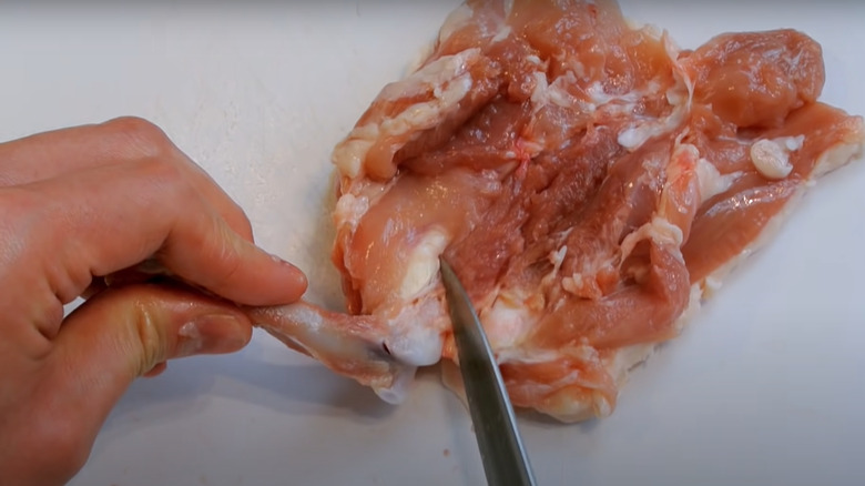 Cutting bone away from chicken thigh