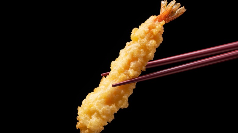 chopsticks holding shrimp tempura