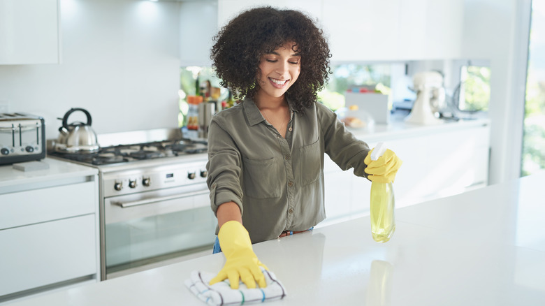 woman cleaning kitchen coutnertops
