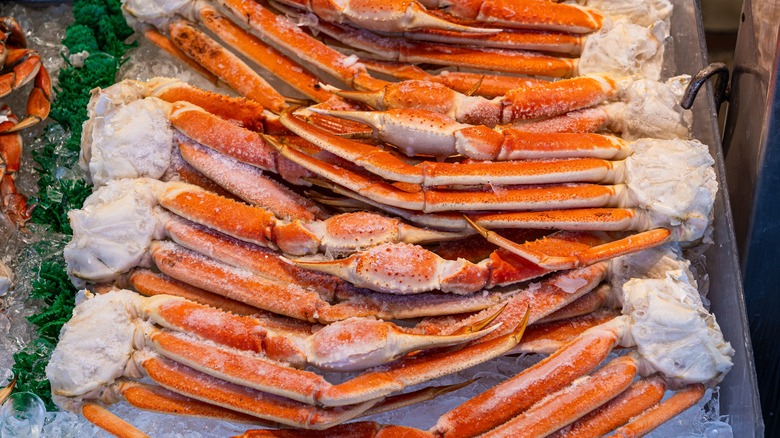 Crab legs sit on a bed of ice on display in a supermarket