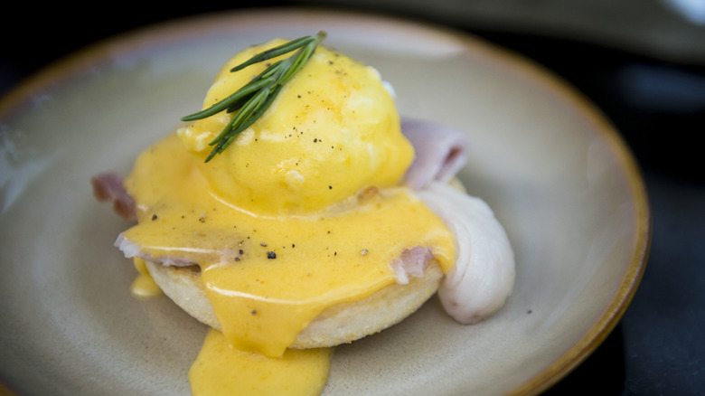 Eggs Benedict with Hollandaise sauce and a sprig of rosemary