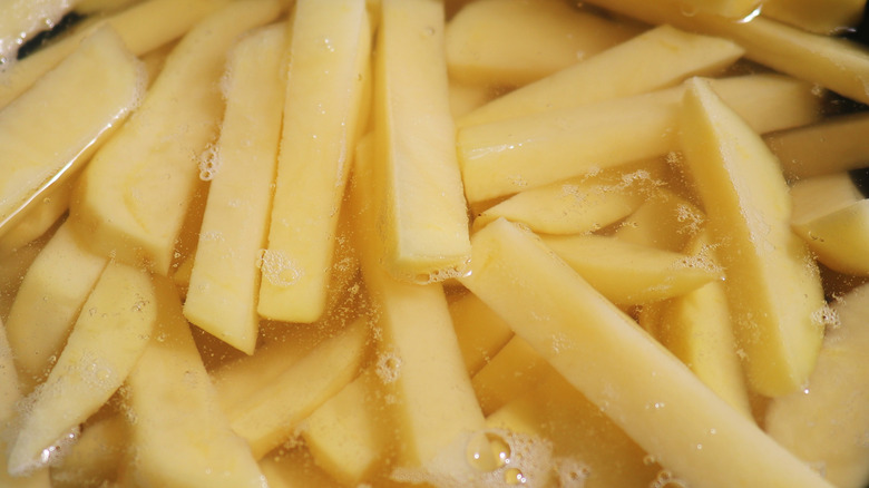 Sliced raw potato in a water bath