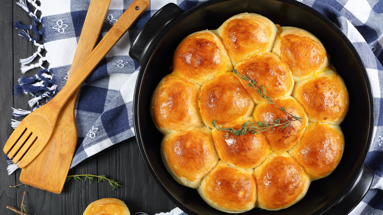 buttery biscuit rolls in cast iron pan on navy and white tablecloth