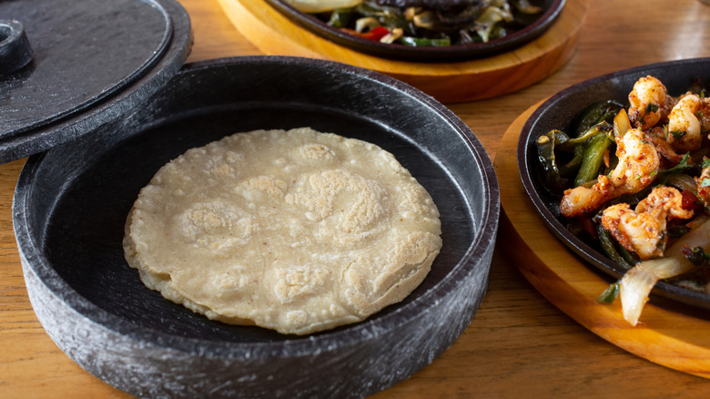 tortillas in a tortilla warmer on wooden table