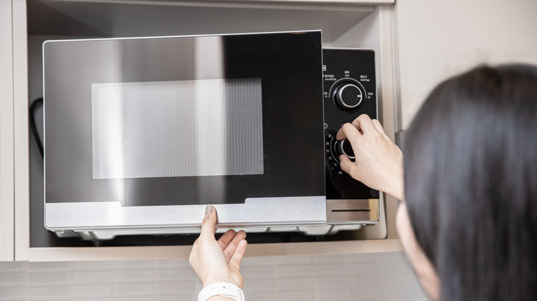 woman using microwave