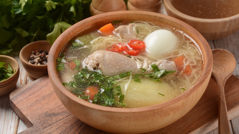 Chicken noodle soup in a wooden bowl.