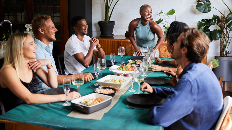 dinner party guests laughing in apartment
