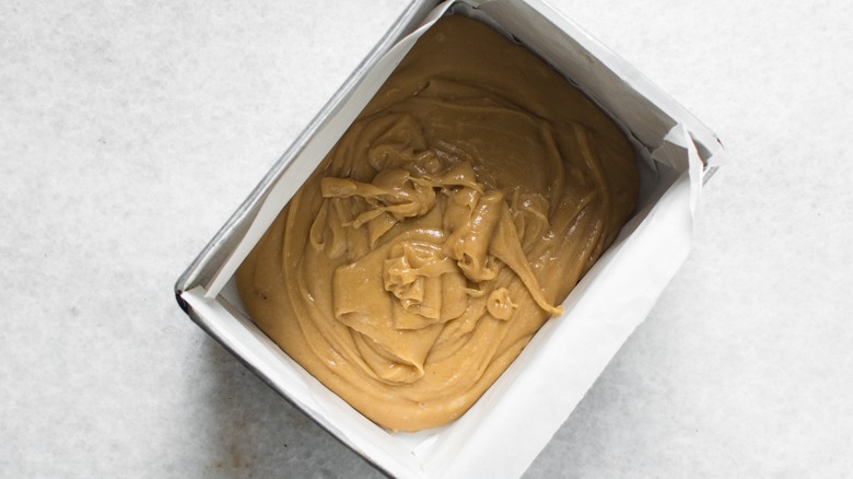 Peanut butter fudge mixture in parchment lined pan