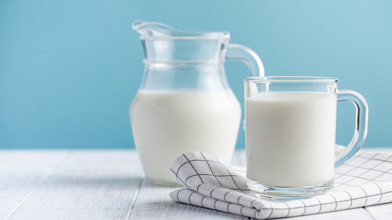 Milk in glass cup and pitcher