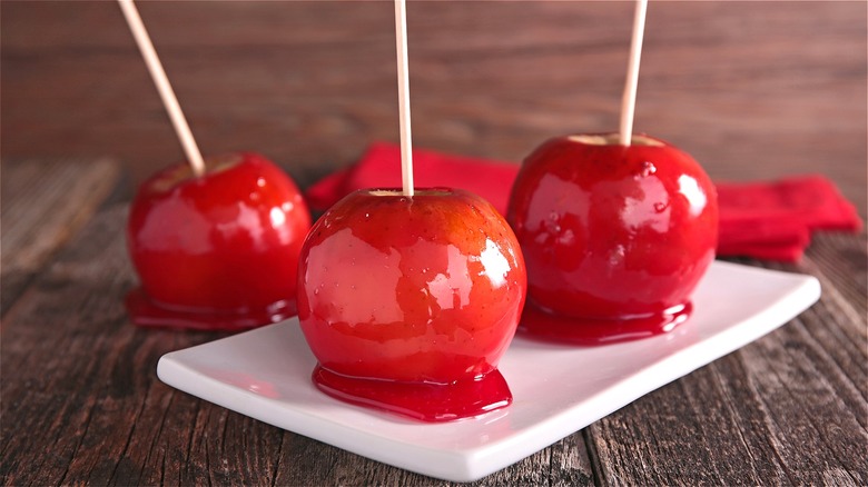 Red candy apples on white plate