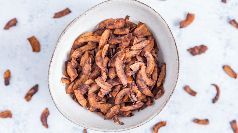 Bowl of baked coconut chips used as a bacon substitute