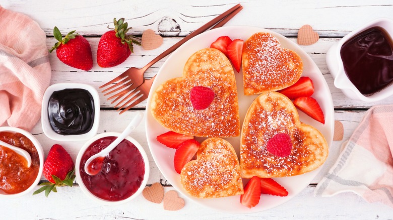 Heart-shaped pancakes on plate with strawberries