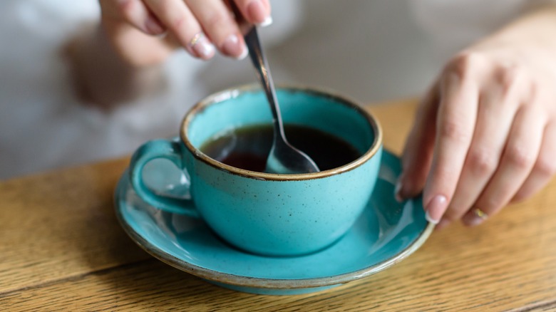 black coffee stirred with spoon