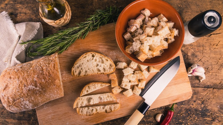 A chopping board with bread and a knife