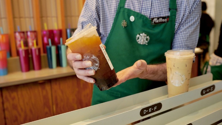 Starbucks barista with mobile order drinks