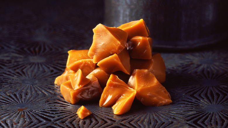 Pieces of broken toffee rest on a metal surface