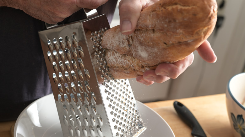 grating stale bread to make breadcrumbs