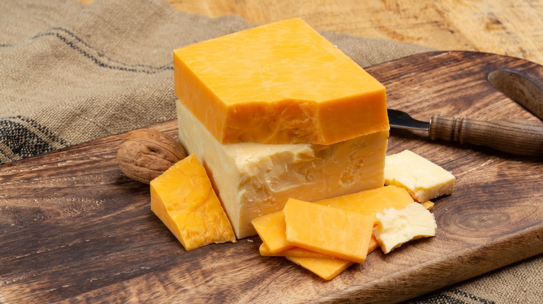blocks of cheddar cheese on wood board