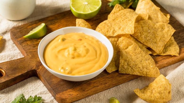 homemade queso cheese dip displayed alongside nacho chips