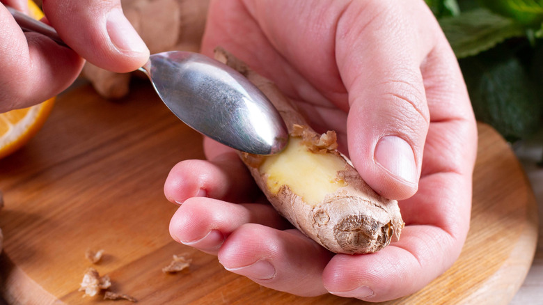 using a spoon's tip to peel ginger