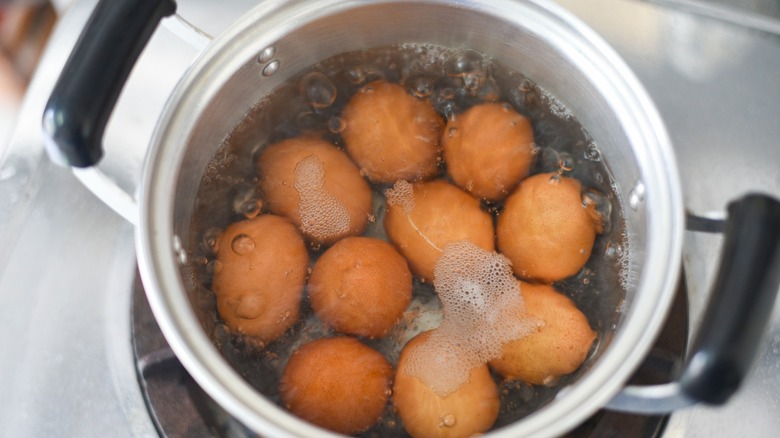 Boiling eggs in pot on stove