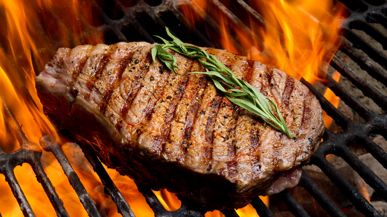 steak on a grill with flames