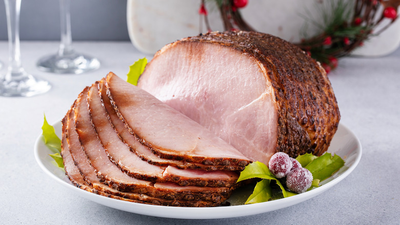 Spiral cut glazed cooked ham on a white plate