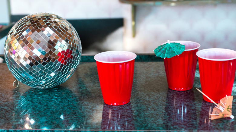 collection of red solo cups next to a disco ball