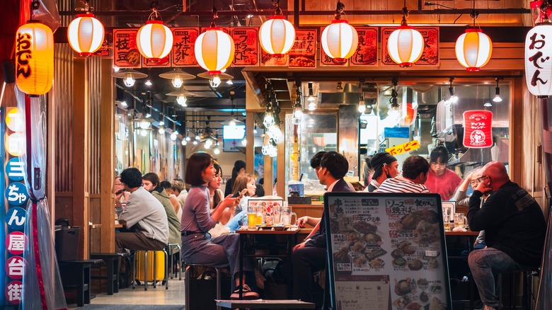 People gather to eat and drink at a bar in Japan