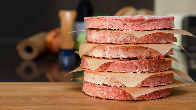 Stack of frozen patties on cutting board